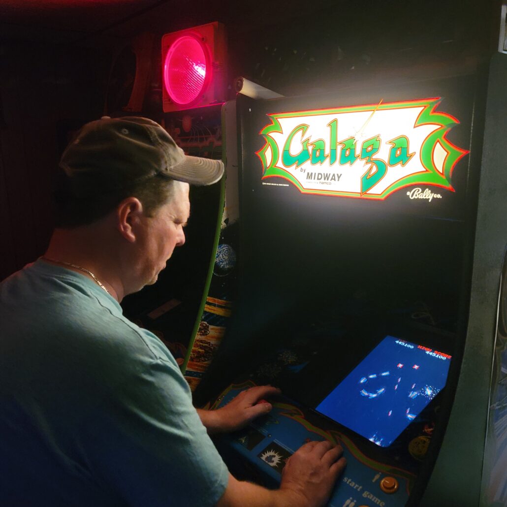 a person playing a custom arcade machine in a room